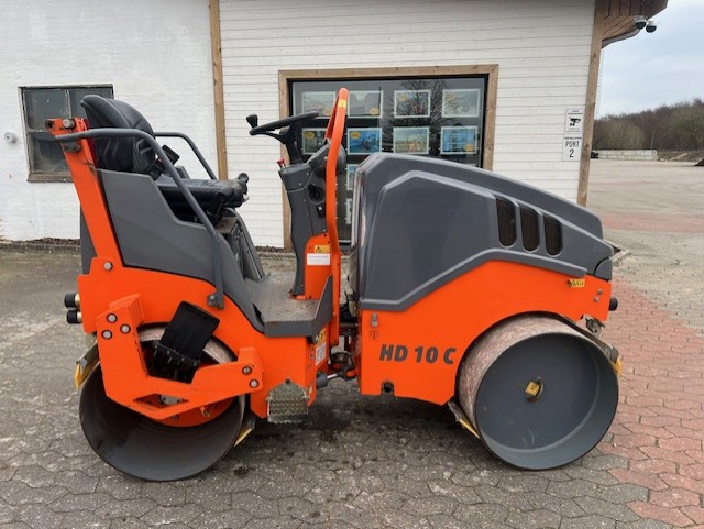 Eight shirts arranged on table in black, olive, grey, blue, white, red, mustard, and green.