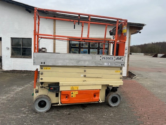 Eight shirts arranged on table in black, olive, grey, blue, white, red, mustard, and green.