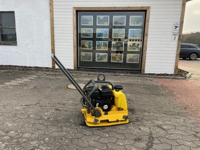 Eight shirts arranged on table in black, olive, grey, blue, white, red, mustard, and green.