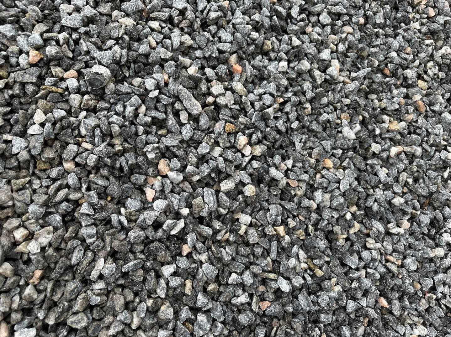 Eight shirts arranged on table in black, olive, grey, blue, white, red, mustard, and green.