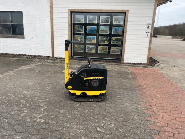 Eight shirts arranged on table in black, olive, grey, blue, white, red, mustard, and green.