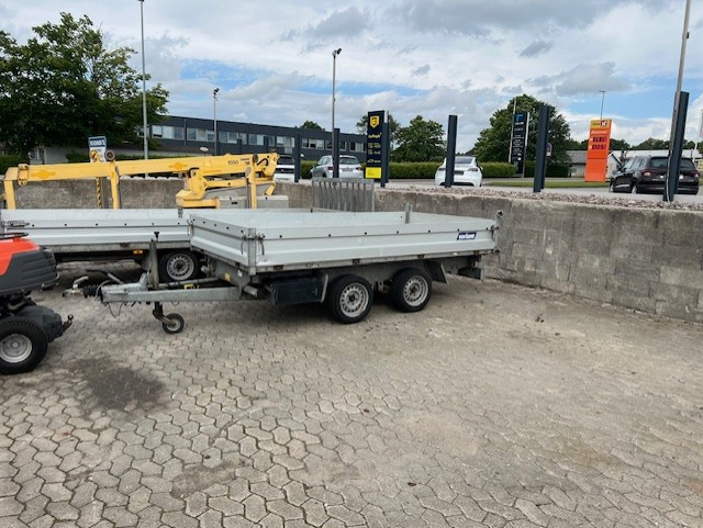 Eight shirts arranged on table in black, olive, grey, blue, white, red, mustard, and green.