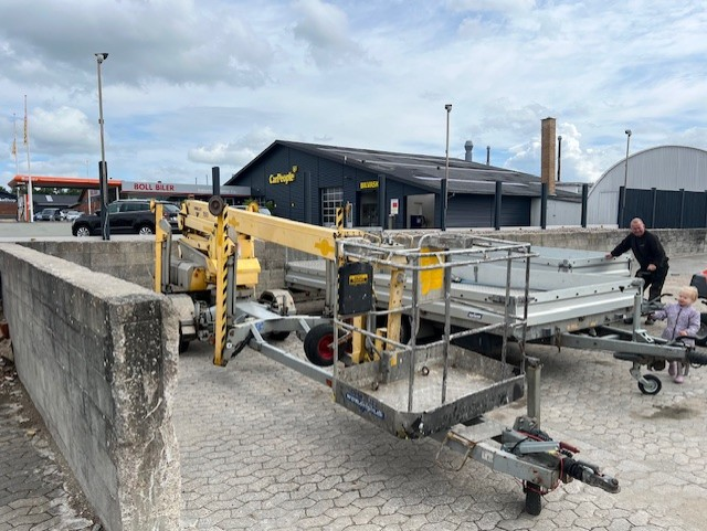 Eight shirts arranged on table in black, olive, grey, blue, white, red, mustard, and green.