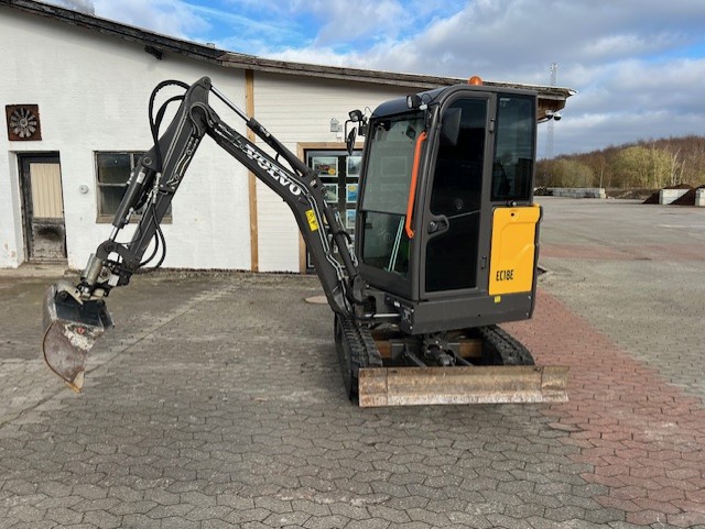 Eight shirts arranged on table in black, olive, grey, blue, white, red, mustard, and green.