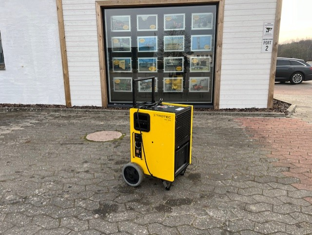 Eight shirts arranged on table in black, olive, grey, blue, white, red, mustard, and green.