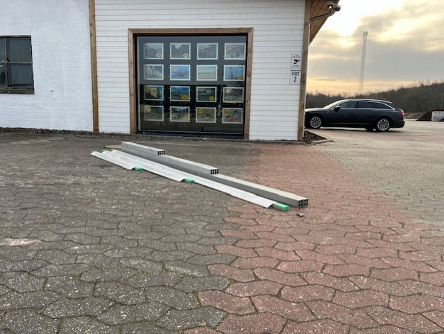 Eight shirts arranged on table in black, olive, grey, blue, white, red, mustard, and green.